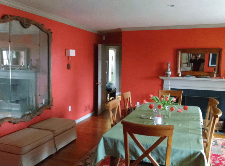 orange walled house with a big mirror and a table in the middle of the room